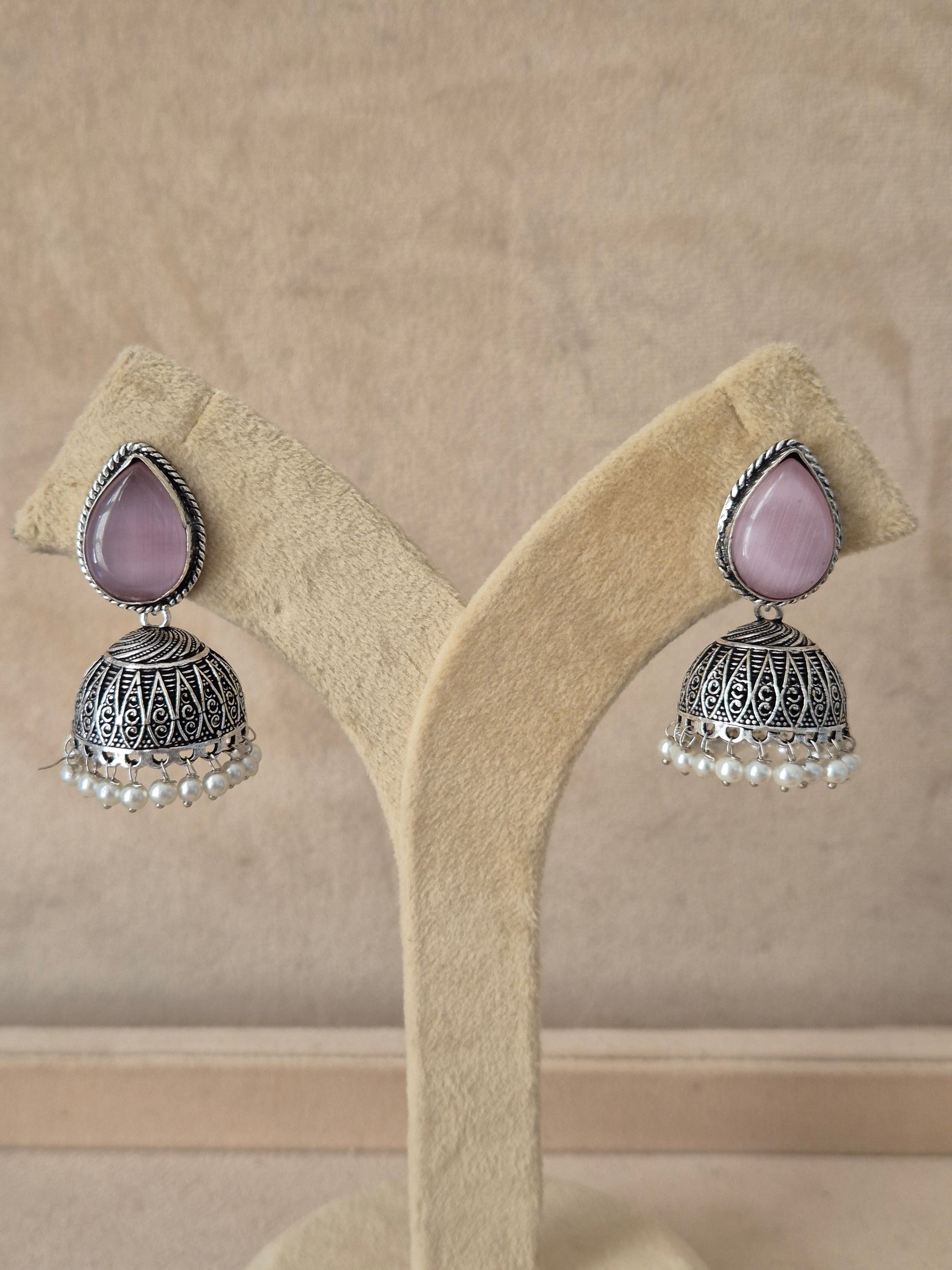 Silver imitation jewelry drop earrings featuring pink stone embellishments and Modern Indian aesthetic silver-plated geometric earrings featuring delicate pink stone details by naitri.in