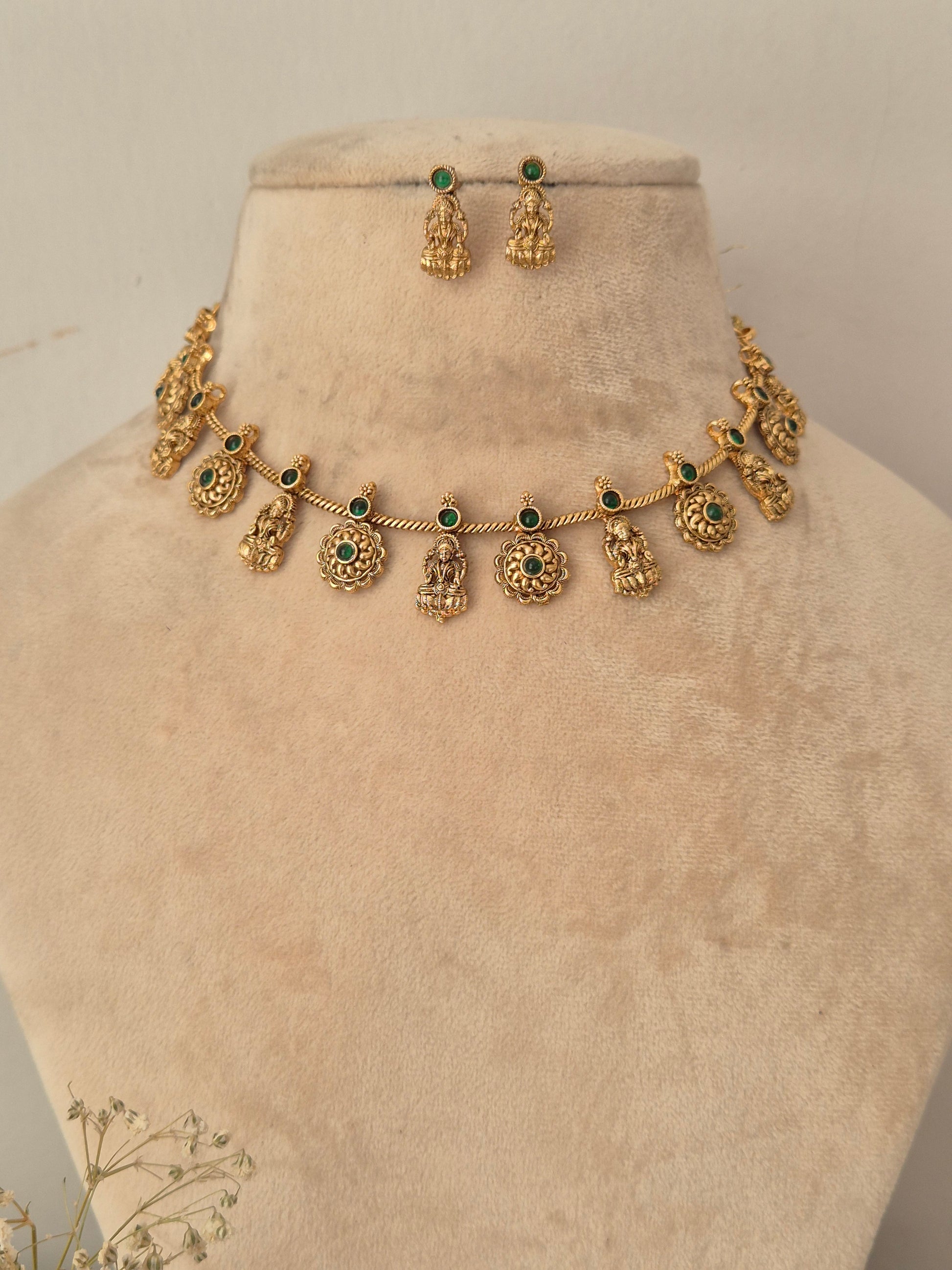 Gold-toned traditional necklace and matching drop earrings displayed by naitri.in