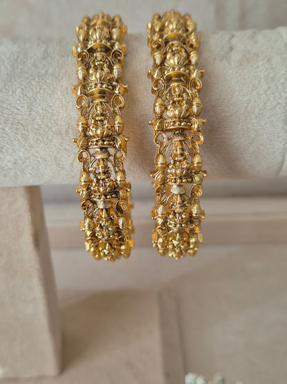 Set of two traditional gold-toned textured bangles. by naitri.in