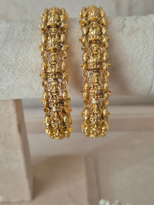 Set of two traditional gold-toned textured bangles. by naitri.in