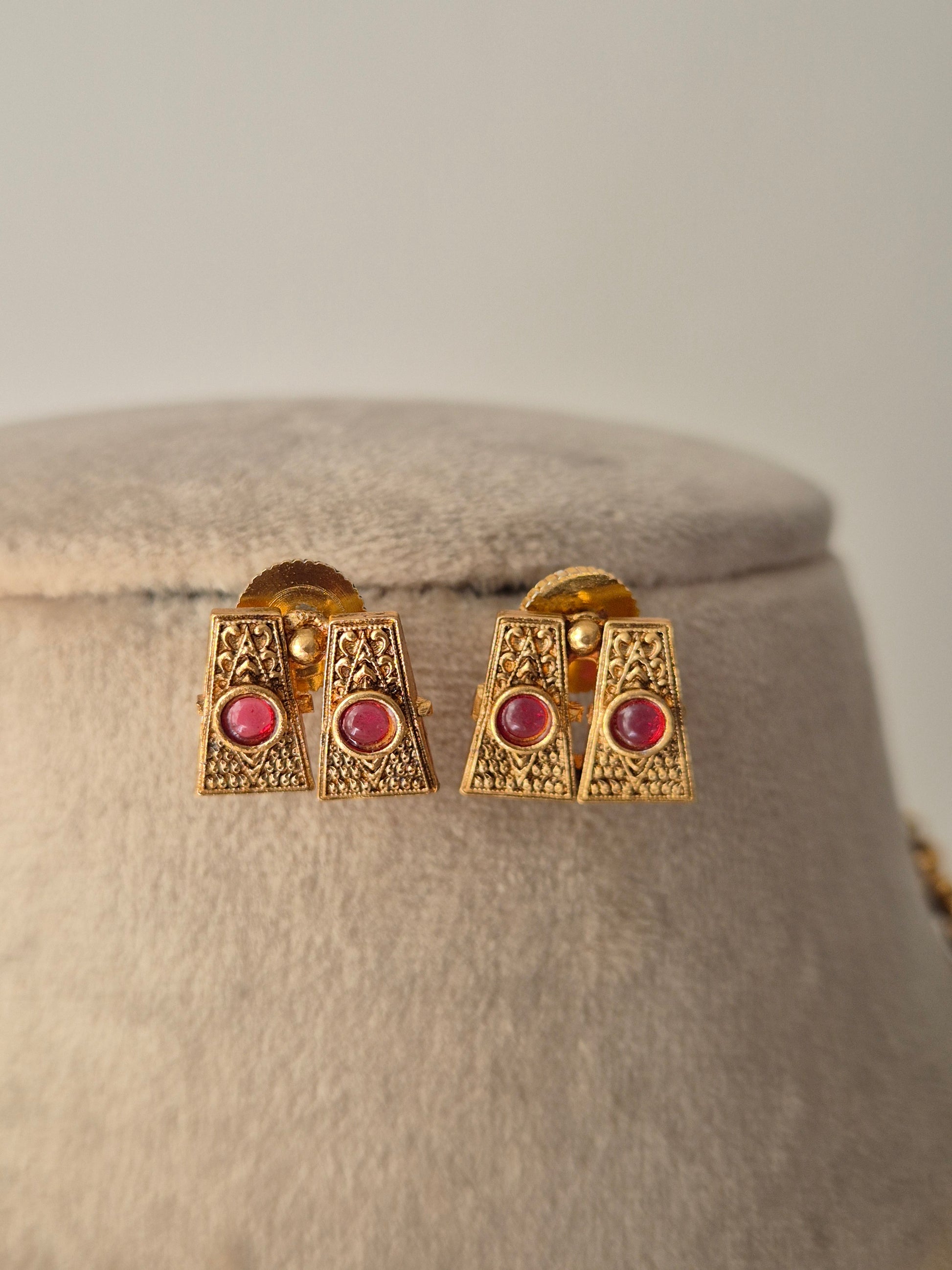 Gold earrings with red gemstones Handcrafted gold-plated brass Antique gold with ruby-colored stone accents by naitri.in