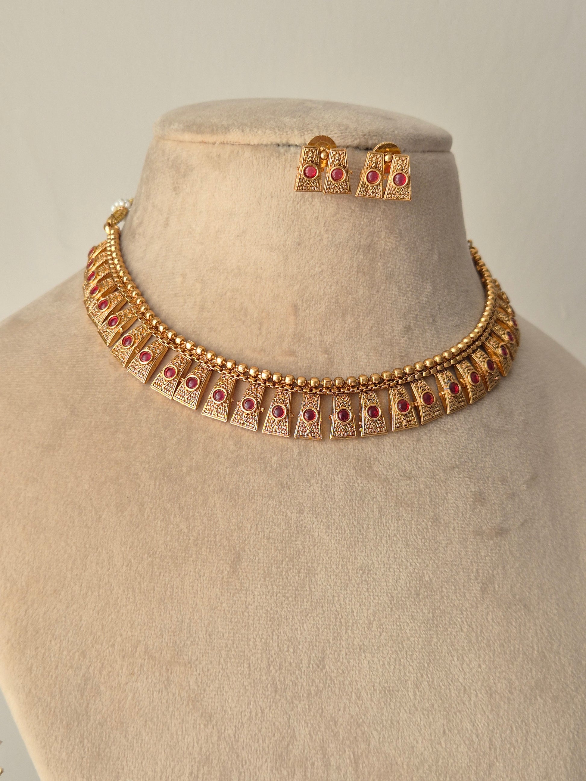 Gold necklace with red stones necklace with same designed earring with red stones by naitri.in