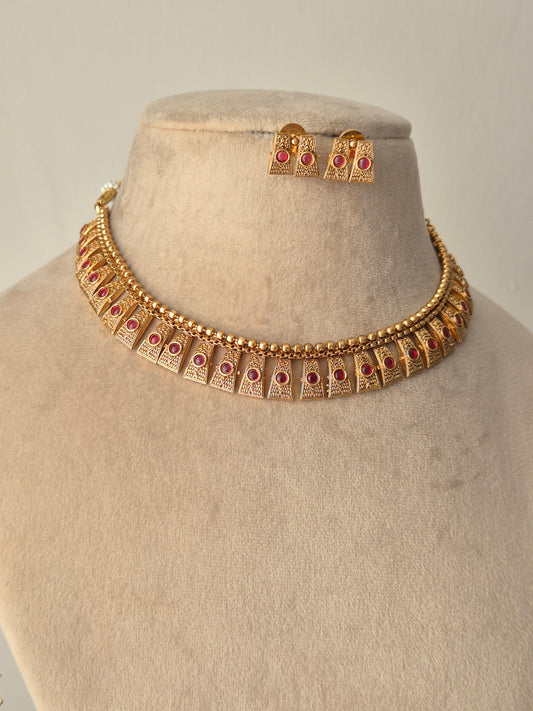 Gold necklace with red stones necklace with same designed earring with red stones by naitri.in