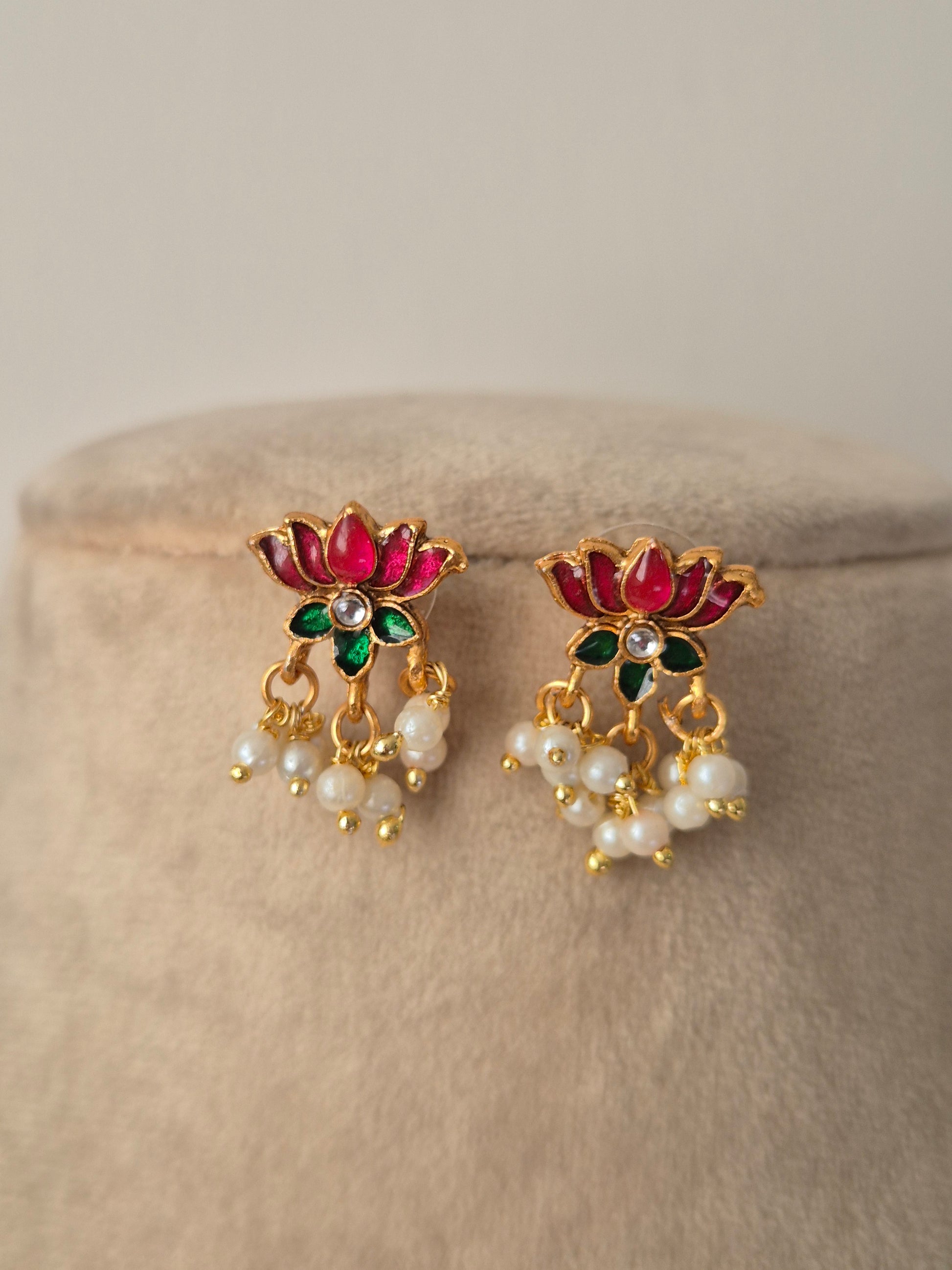 Pair of decorative earrings with pink and gold lotus design a small stone in middle of flower and some pearls hanging from flower by naitri.in