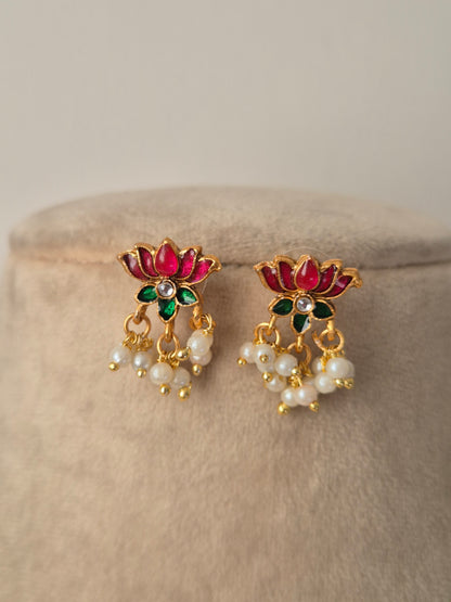 Pair of decorative earrings with pink and gold lotus design a small stone in middle of flower and some pearls hanging from flower by naitri.in