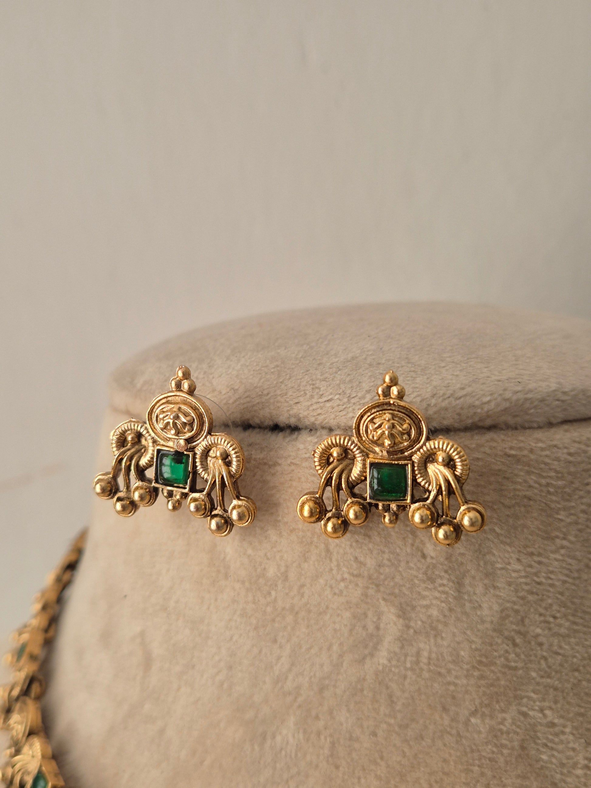 A pair of gold-toned earrings with square green gemstones, by naitri.in