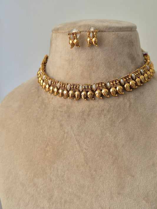 minimal Gold necklace leaf designed and some white stones are attached with chain same with earrings by naitri.in 