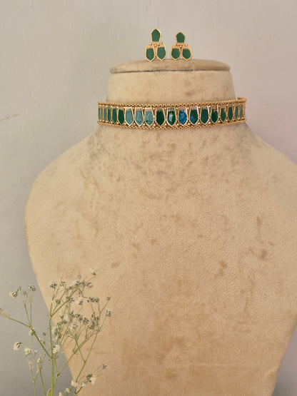 gold-toned traditional Indian choker necklace and matching drop earrings decorated with vibrant green marquise-cut stones, by naitri.in