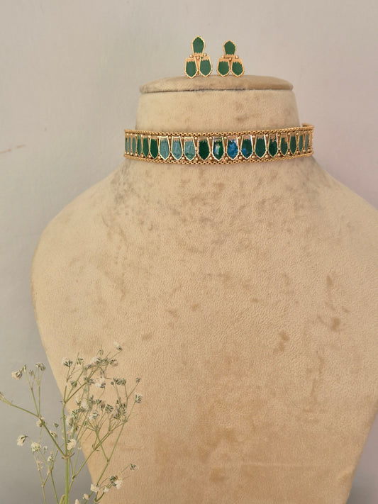 gold-toned traditional Indian choker necklace and matching drop earrings decorated with vibrant green marquise-cut stones, by naitri.in