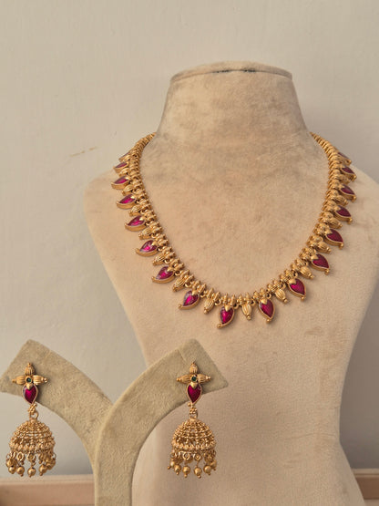 Gold antique necklace set with teardrop ruby stone accents and matching dangling jhumka earrings by naitri.in