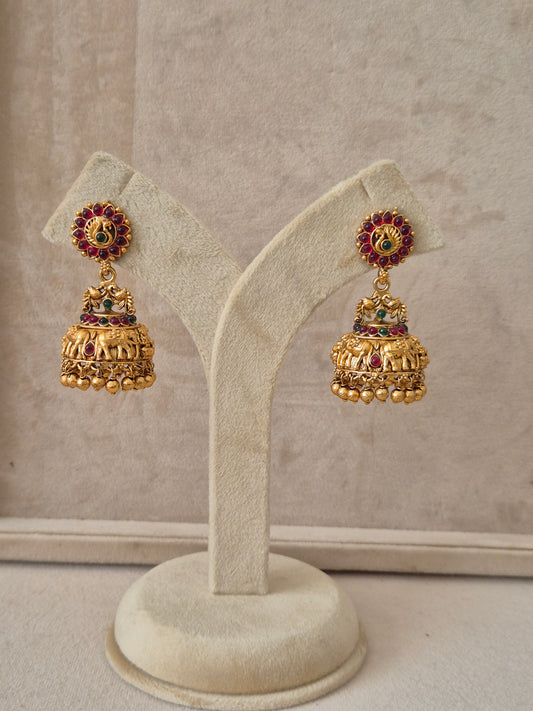 Traditional gold-toned Fanaa Jhumka earrings featuring floral studs with red and green gemstone accents and embossed elephant motifs by naitri.in
