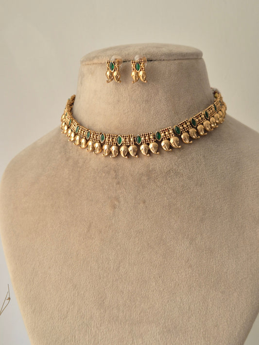 minimal Gold necklace leaf designed and some green stones are attached with chain same with earrings by naitri.in 