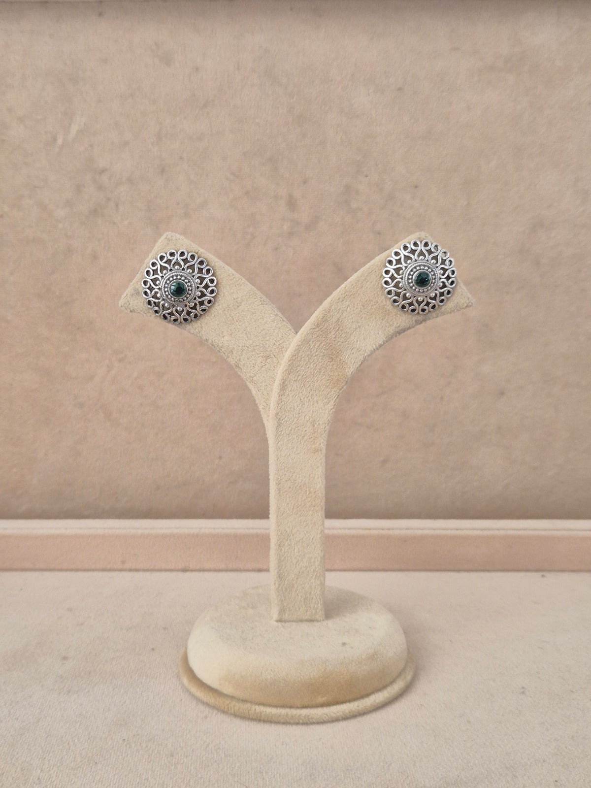 A pair of silver-toned filigree stud earrings with dark blue-green stone centers, by naitri.in