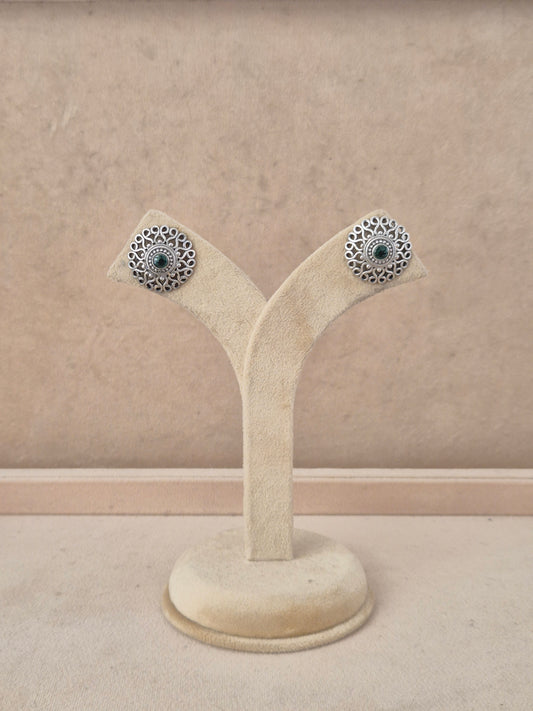 A pair of silver-toned filigree stud earrings with dark blue-green stone centers, by naitri.in