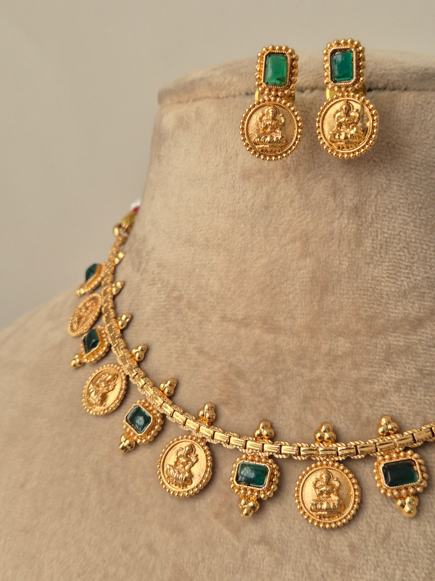 Gold jewelry set with emerald stones goddess motifs crafted antique craftmanship by naitri.in