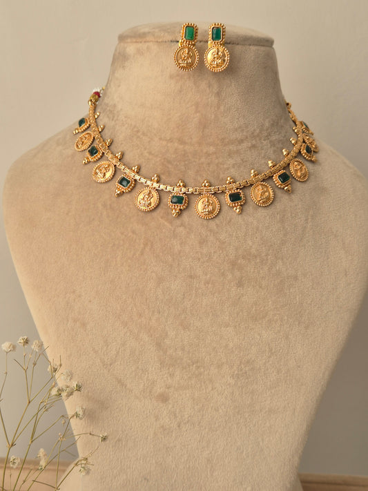 Gold necklace with green coin designed  Naitri on bust form by naitri.in