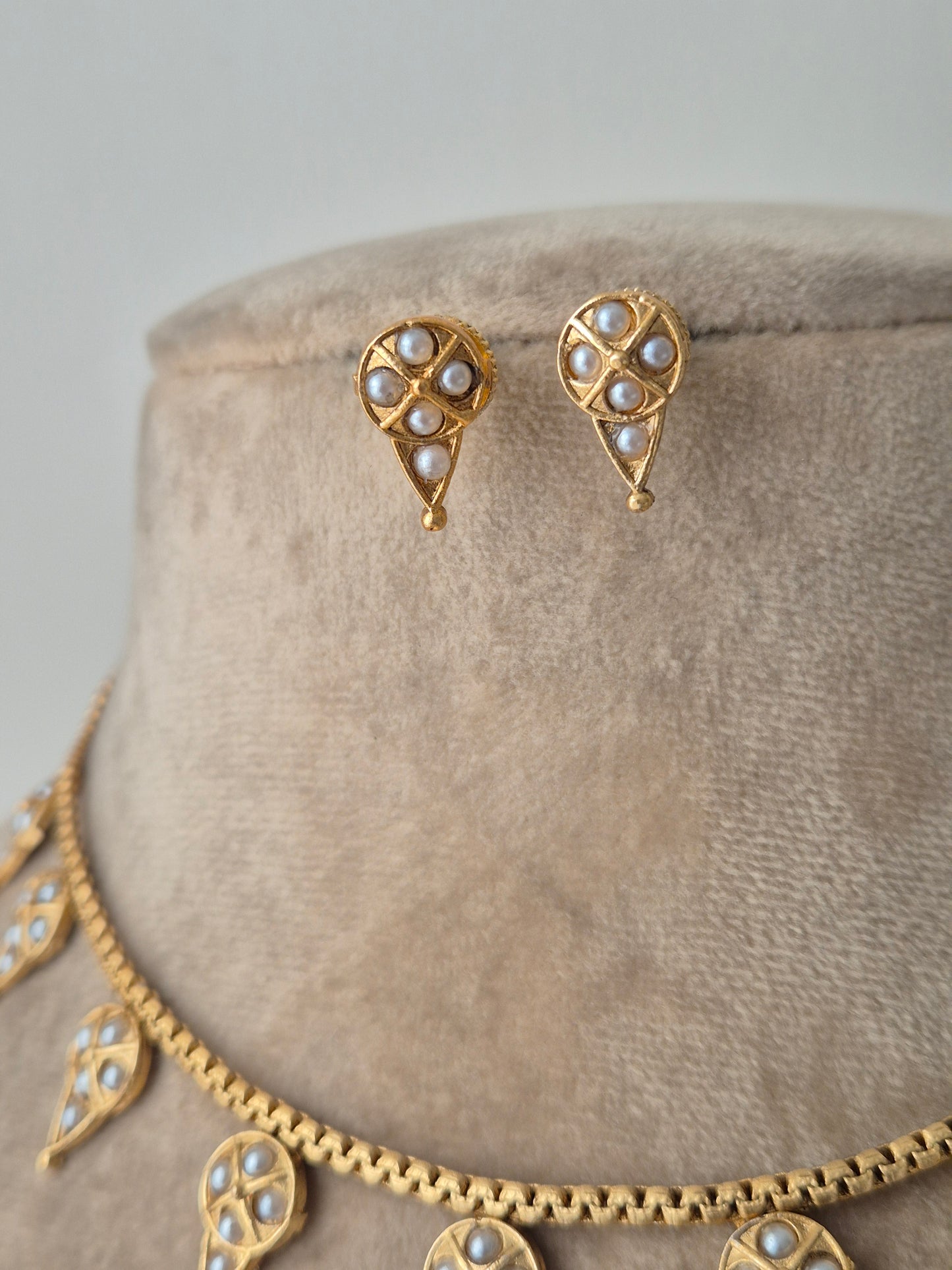 Cutely designed earring with golden drop shaped and small pearls attached on the earring fine and minimal by naitri.in