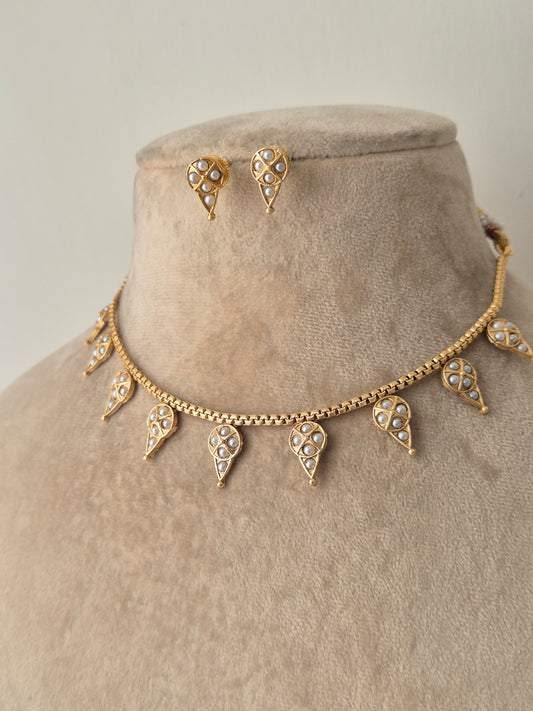 Gold neck piece with decorative pearl making the drop shaped Simple