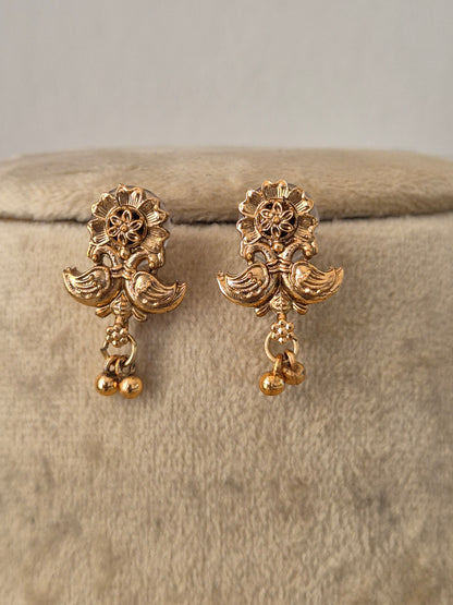 A pair of gold-toned traditional Indian jhumka earrings with floral and bird motifs, by naitri.in