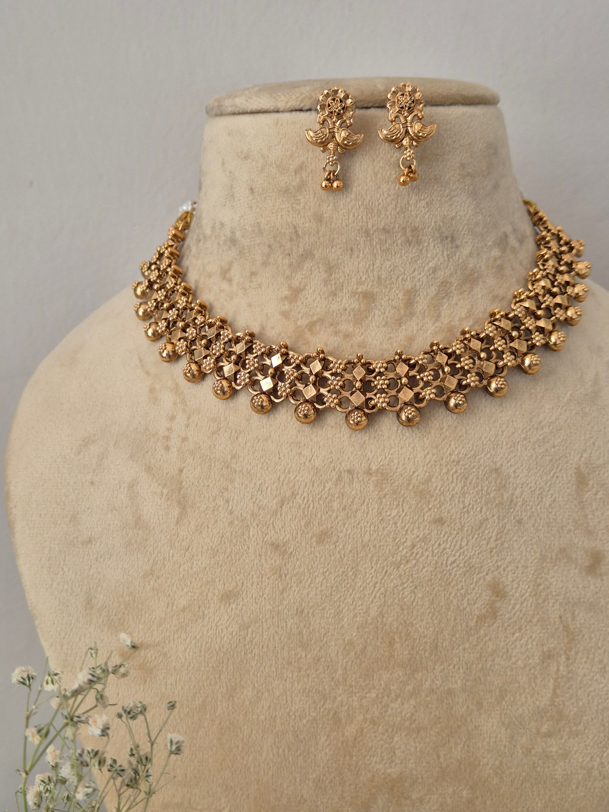 Necklace Set featuring an ethnic gold-plated choker and matching antique-style dangle earrings for festive wear by naitri.in