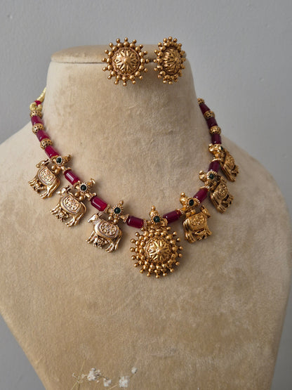  Traditional gold-plated choker with red stone accents and matching floral studs by naitri.in
