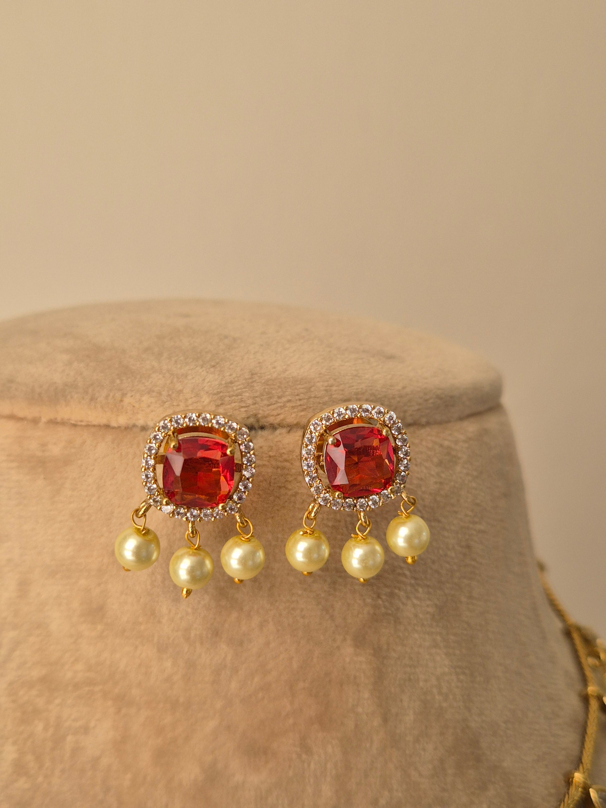 Pair of earrings with pink gemstones and pearl-like beads and rinestone in the side of pink stone by naitri.in