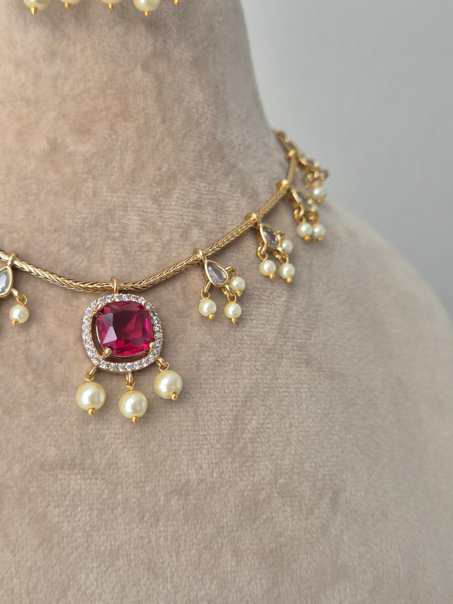 Gold-plated pink gemstones and necklace set of Brass Alloy is actually quite good, but adding the pearl and clear stone accent details makes it even better by naitri.in