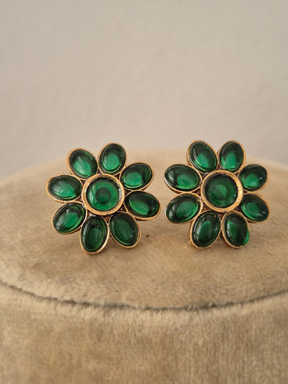 Pair of  earrings embedded with vibrant emerald-green stones in a floral pattern, by naitri.in