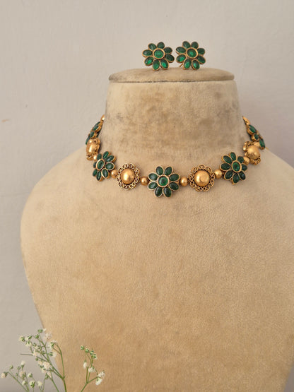 Elegant green gemstone and gold-toned traditional choker jewelry set, Gold-plated choker necklace with green floral gemstones and matching stud earrings by naitri.in 
