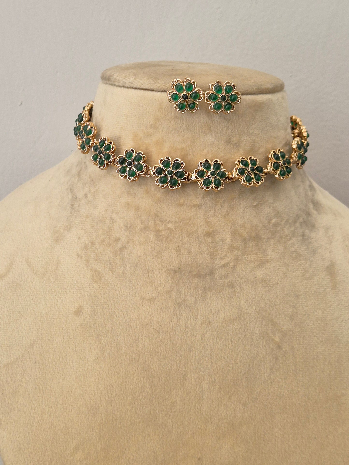 Elegant green stone and gold-toned ethnic choker necklace set, styled on a minimalist by naitri.in
