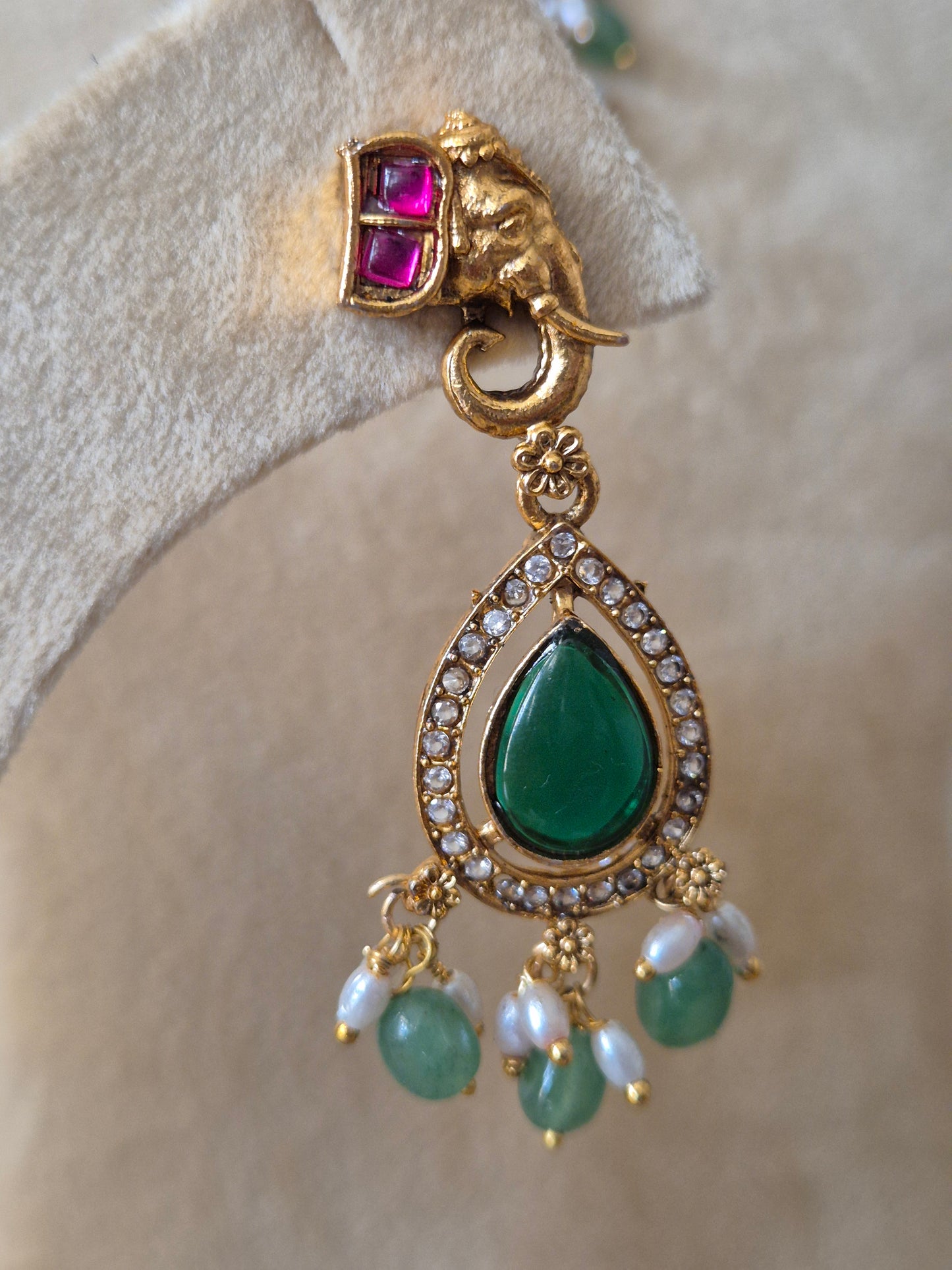 Handcrafted antique gold jewelry with intricate craftsmanship, featuring vibrant pink elephant motifs, green gramstone and beads and traditional ethnic design by naitri.in