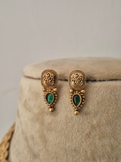 A pair of gold-toned traditional earrings with green teardrop-shaped stones, by naitri.in