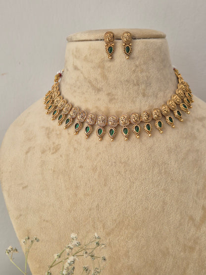 Gold-toned traditional jewelry set featuring a necklace and matching earrings with green stone accents, for festive wear by naitri.in