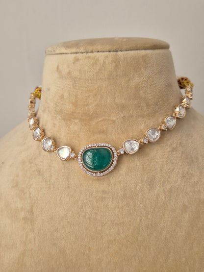 Statement alloy necklace set with clear American diamonds and a central green stone for festive occasions by naitri.in