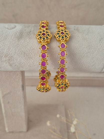 Set of two ruby and emerald stone-studded gold-plated bangles by naitri.in