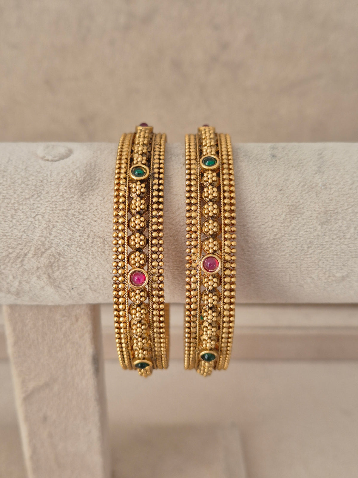 Set of two pink and green stone-studded gold-plated bangles by naitri.in