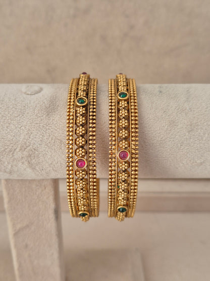 Set of two pink and green stone-studded gold-plated bangles by naitri.in