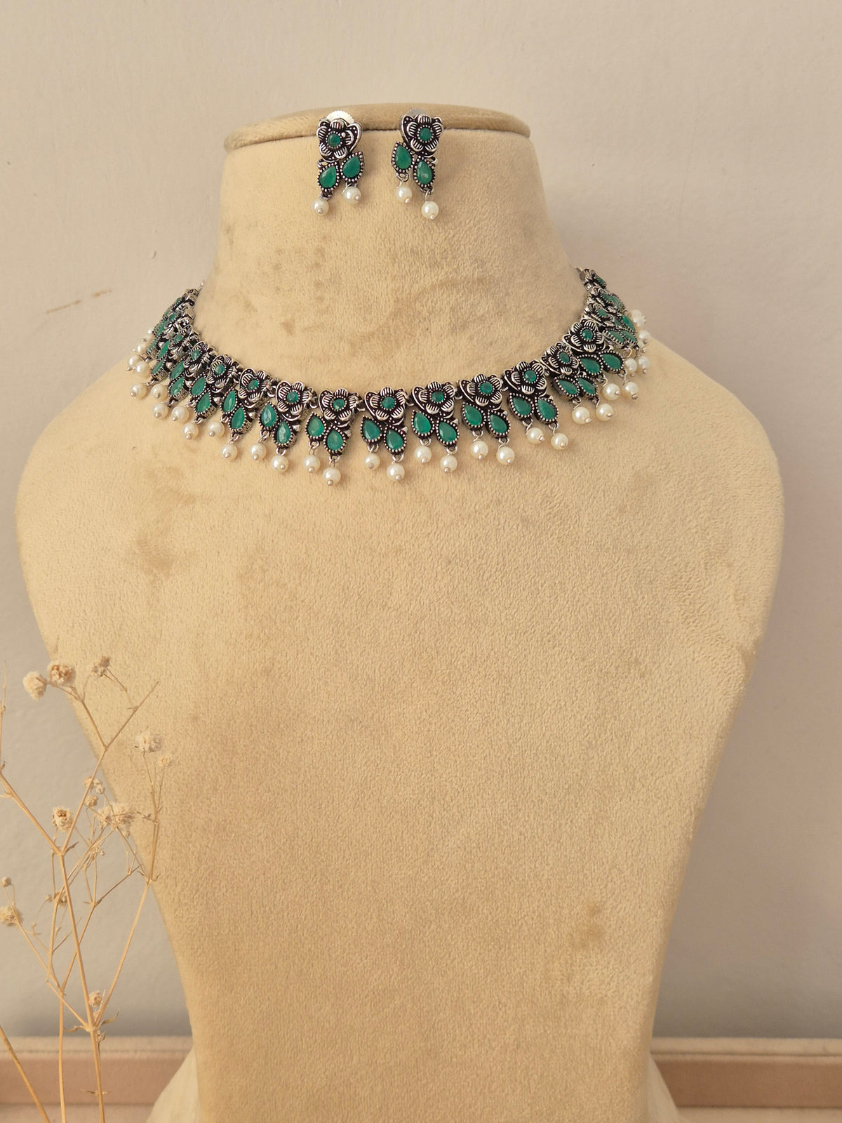 Gopika silver oxidized necklace set with green stone embellishments and pearl drop accents by naitri.in