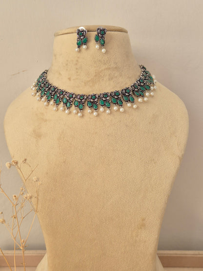 Gopika silver oxidized necklace set with green stone embellishments and pearl drop accents by naitri.in