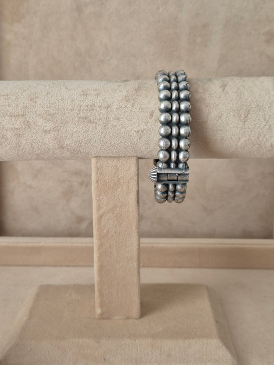 Antique silver oxidized Anchal bangle with an intricate textured design and fine geometric border engraving, by naitri.in