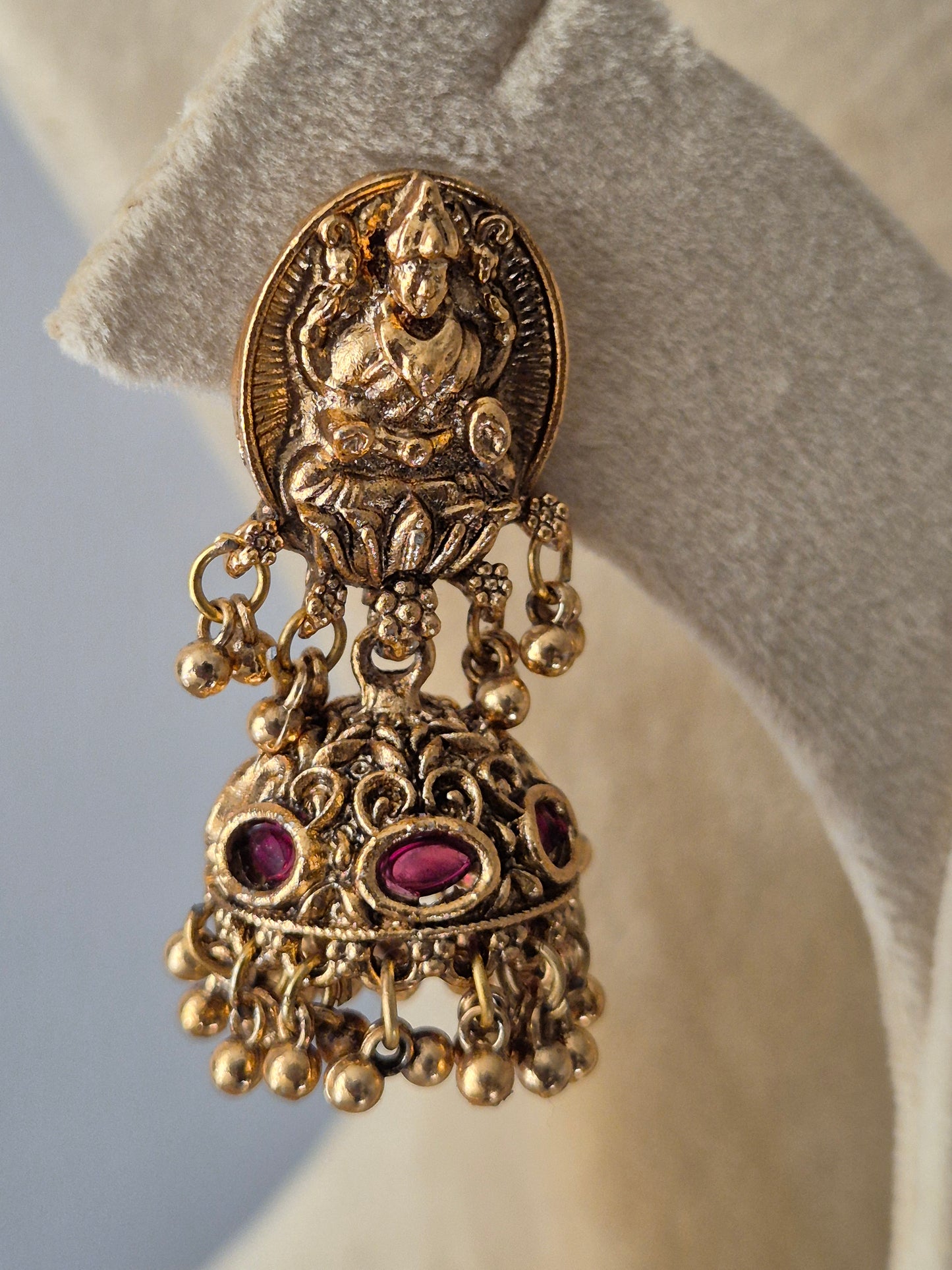 Handcrafted temple earrings - jhumkis featuring a gold-toned goddess Lakshmi with pink stones and gold bead droplets by naitri.in