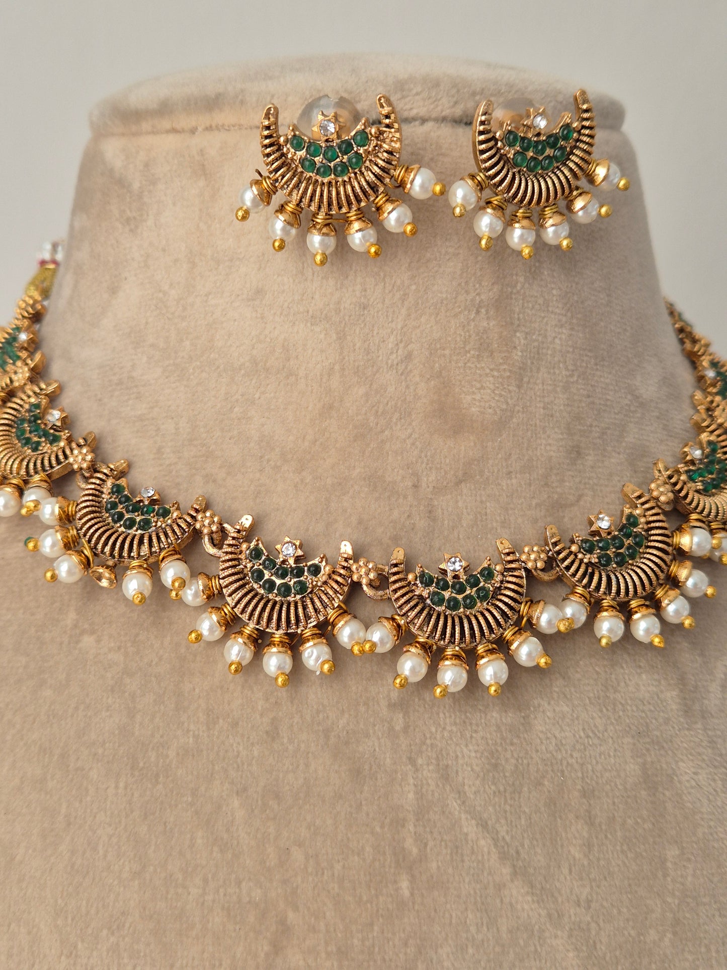 Detailed half moon and green stones in the middle with pearls attached outside eye-catching jewellery by naitri.in
