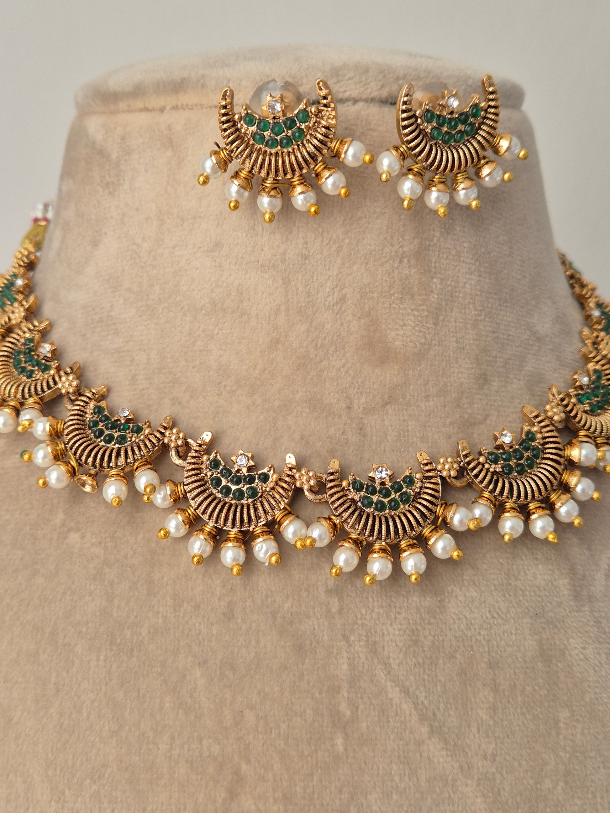 Detailed half moon and green stones in the middle with pearls attached outside eye-catching jewellery by naitri.in