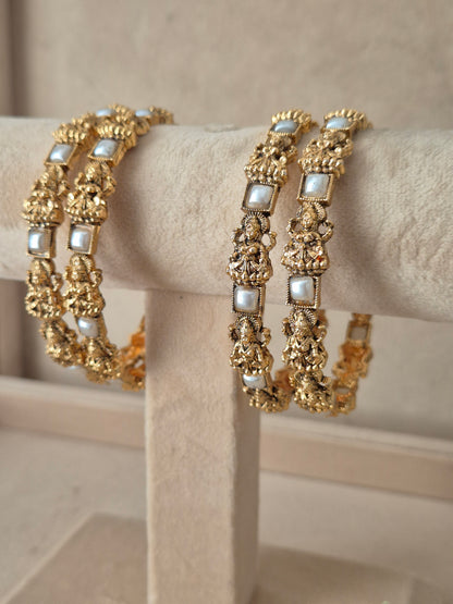 Four ethnic antique gold-plated temple jewelry bangles with with white square beads, for festive and wedding wear by naitri.in