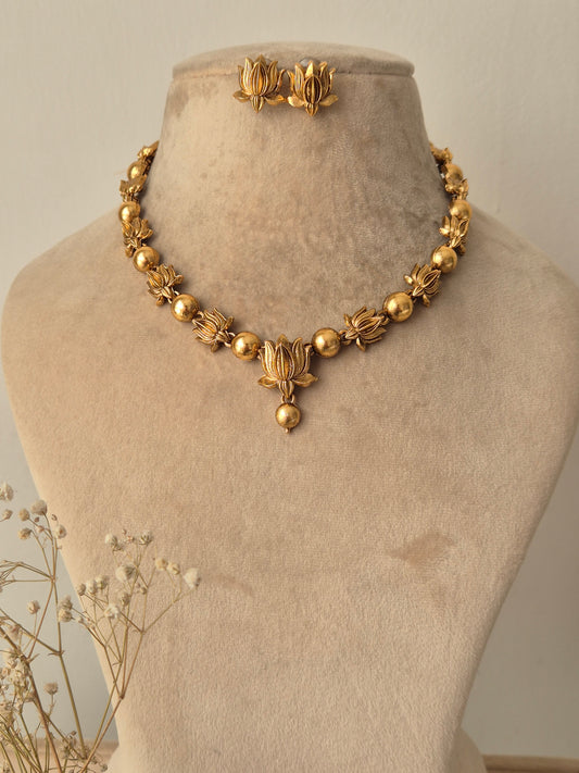 Handcrafted golden brass alloy necklace with traditional floral motifs and matching stud earrings, By naitri.in