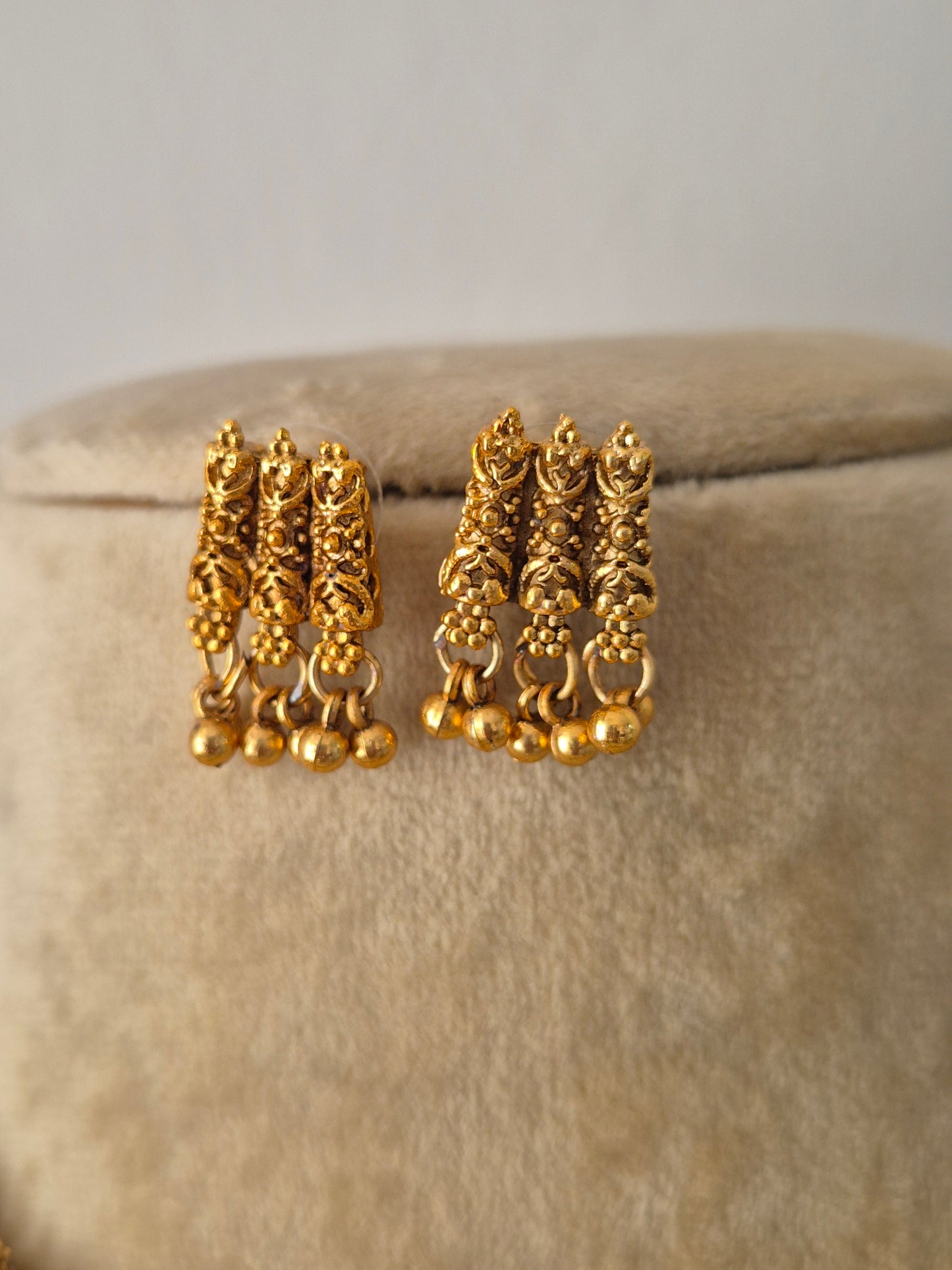 Gold earring textured gold patterns and a row of hanging golden bead droplets, by naitri.in