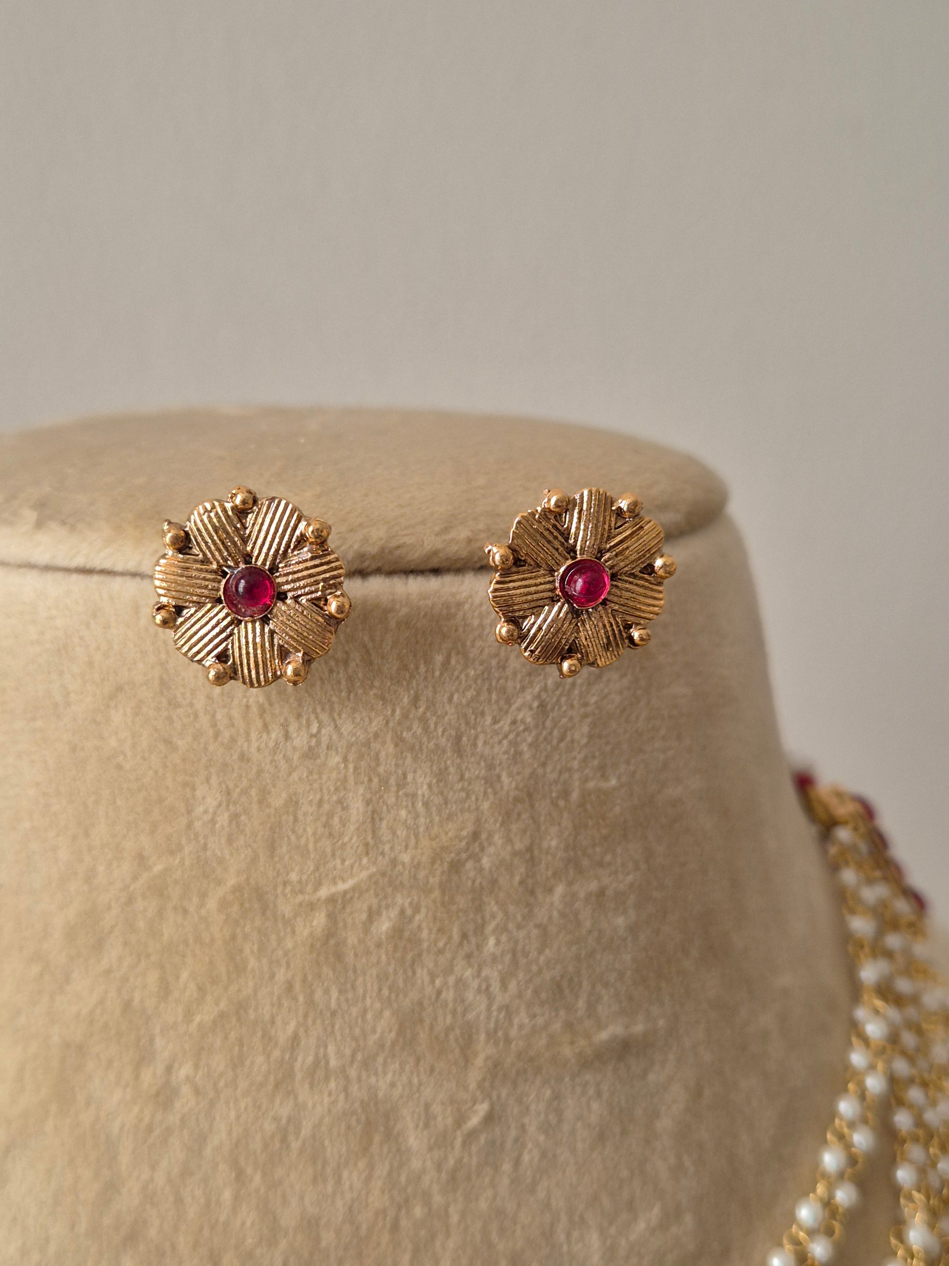 a pair of gold-toned floral-shaped stud earrings by naitri.in