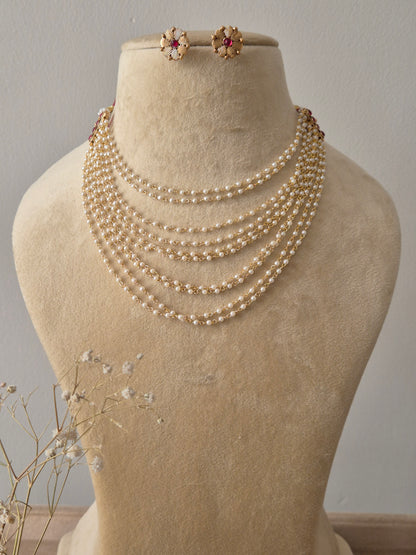 Multilayered white pearl strand necklace  with red gemstone accents and matching floral stud earrings by natri.in