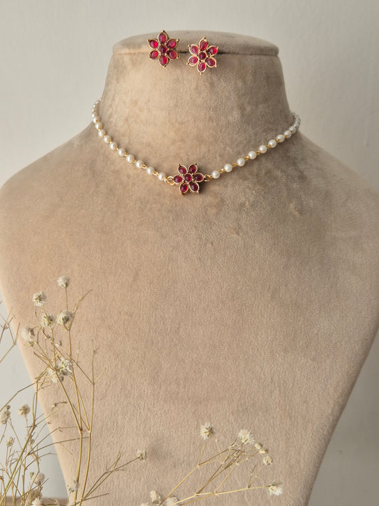 Pearl choker necklace with a pink stone floral pendant and matching stud earrings by naitri.in