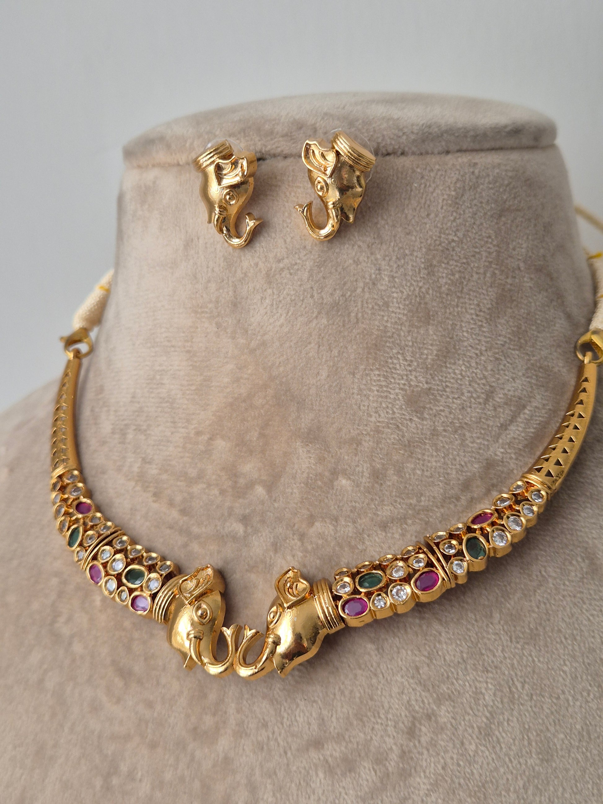 Elephantastic golden necklace set with small studs with colourful stones by naitri.in